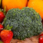 A vibrant collection of fresh, organic fruits and vegetables on a wooden table, showcasing healthy variety.